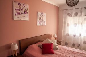 ラゴスにあるCasa Polaのピンクの壁のベッドルーム1室、ベッド1台(赤い枕付)