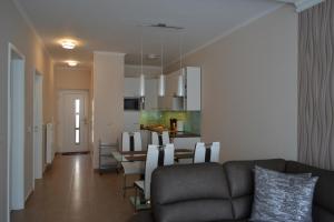 sala de estar y cocina con sofá y mesa en A17 Beachapartman, en Siófok