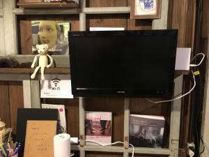 a flat screen tv sitting on a shelf with books at Guest house AmaMin in Amami +10 photos