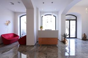 sala de estar con sofá rojo y ventanas en Best Western Hotel Principe di Lampedusa en Palermo