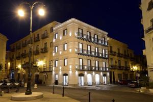 duży biały budynek w nocy z światłem ulicznym w obiekcie Best Western Hotel Principe di Lampedusa w mieście Palermo