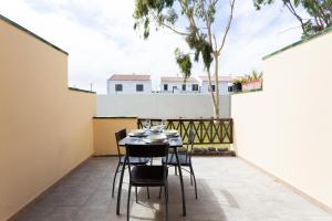 einen Tisch und Stühle auf dem Balkon eines Hauses in der Unterkunft Tagoro Park in Costa Del Silencio