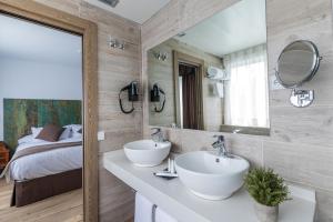 a bathroom with two sinks and a bed at Suite Home Pinares in Santander