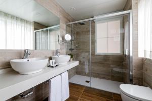 a bathroom with two sinks and a shower at Suite Home Pinares in Santander