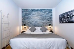 a bedroom with a large bed with a brick wall at Suite Home Pinares in Santander
