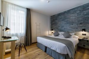 a bedroom with a large bed with a brick wall at Suite Home Pinares in Santander