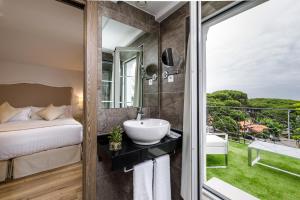 a bathroom with a sink and a bed and a window at Suite Home Pinares in Santander