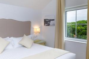 a bedroom with a white bed and a large window at Suite Home Pinares in Santander