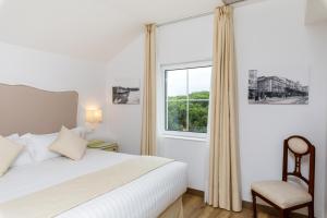 a bedroom with a white bed and a window at Suite Home Pinares in Santander