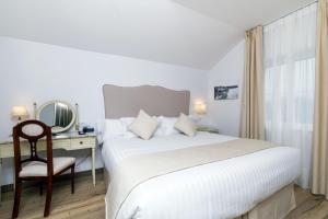 a bedroom with a bed and a desk with a mirror at Suite Home Pinares in Santander