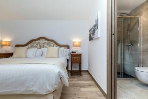 a bedroom with a large bed and a glass shower at Suite Home Pinares in Santander