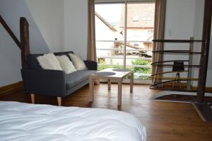 アンドーにあるGîte à Andlauのベッドルーム1室(ベッド1台、椅子、テーブル付)