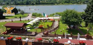 un parque con mesas y sombrillas junto a un lago en Rheinhotel Bellavista, en Braubach