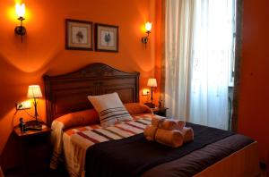 a teddy bear sitting on top of a bed at Hostal Alfonso in Santiago de Compostela