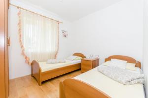 a bedroom with two beds and a window at Beach & park Apartment in Kaštela