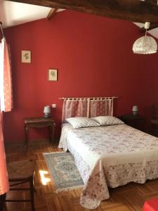 een slaapkamer met een bed in een rode muur bij la raymondiere in Vernoux-en-Gâtine