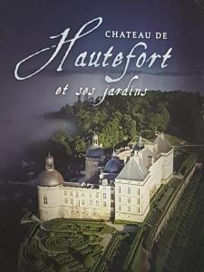 a book cover of a white building with trees at Au Périgord Noir in Hautefort