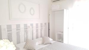 Habitación blanca con cama con almohadas en Casa Vittoria, en Milazzo