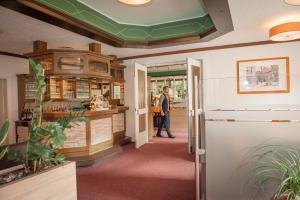 a man walking through a store with a green ceiling at Hotel Quellenhof in Mölln