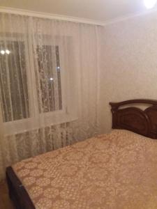 ウラジカフカスにあるApartment dlya bolshoi semyi na Vesenniyのベッドルーム1室(ベッド1台付)、窓(カーテン付)