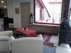 een woonkamer met een tafel en stoelen en een raam bij A casa de Mateu in Pontevedra