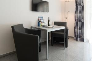 ツェルマットにあるA Calm & Charm Studio - Haus Haroの白いテーブル(椅子2脚付)とワイン1本