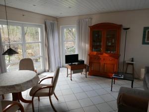 a living room with a television and a table and chairs at Ferienwohnung Prophet in Kiel