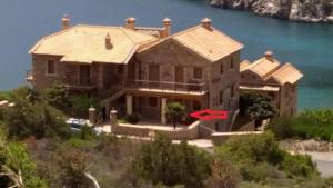a large house with a red arrow in front of it at Two-storey Mansion at the Sea in rkadiko Chorio
