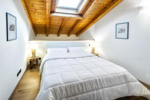 a bedroom with a large white bed with a wooden ceiling at Stella Marina 1 in Venice