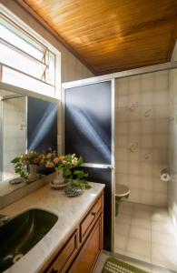 uma casa de banho com um lavatório e um chuveiro em Águas do Pantanal Inn Pousada em Miranda