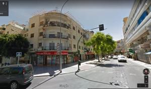 uma rua da cidade com um semáforo e um edifício em Piso 3 dormitorios centro de Torremolinos 11349 em Torremolinos