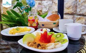 zwei Teller Essen auf einem Tisch mit Obst darauf in der Unterkunft Hostal Blue Pacific in Manta