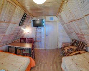 a room with a bed and a table and a tv at Papartis in Ažuluokesa