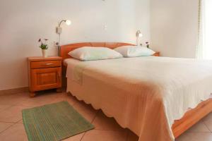 a bedroom with a large bed and a nightstand with two lamps at Casa Limone in Belej