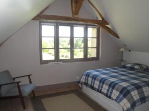 1 dormitorio en el ático con cama y ventana en La Suite Du Marquis, en Saint-Paterne-Racan