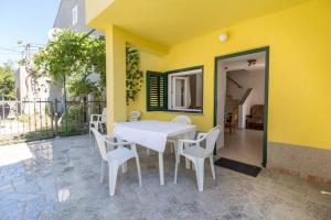 a white table and chairs on a yellow wall at Casa Limone in Belej