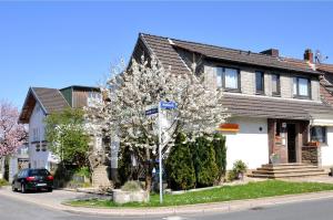 a tree in front of a house with a street sign at Pension Bella Vista in Bochum