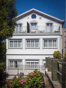 Casa blanca con balcón en la parte superior. en Suite Home Pinares, en Santander