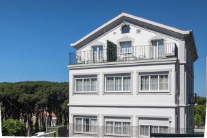 a white building with a balcony on top of it at Suite Home Pinares in Santander