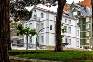 a large white building with trees in front of it at Suite Home Pinares in Santander