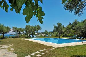 a swimming pool in a yard with a view of the water at Limanaki in Tsilivi
