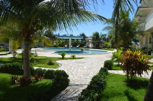 un complejo con piscina y palmeras en Apartamento 150m da praia de Canoa Quebrada, en Canoa Quebrada