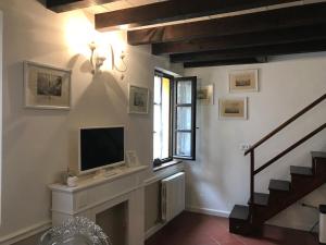 a living room with a television and a fireplace at MANSARDA57 in Parma