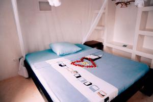 a room with a bed with a blue and white sheets at Jamala Guesthouse in Lamu