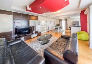 uma sala de estar com um sofá de couro e uma televisão em Apartments LUPE em Split