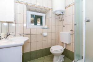 a bathroom with a toilet and a sink and a window at Casa Limone in Belej +16 photos
