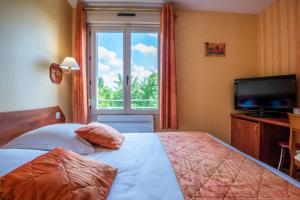een slaapkamer met een bed, een tv en een raam bij Logis le Relais de Vacherauville in Vacherauville