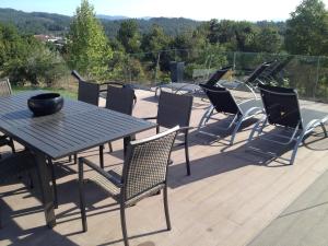 eine Terrasse mit einem Tisch und Stühlen auf einer Terrasse in der Unterkunft Villa Piscine Portugal in Coucieiro