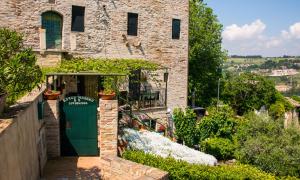 a building with a green door in a garden at B&B Borgo Marano in Cupra Marittima
