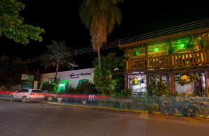 um edifício com luzes verdes ao lado de uma rua em Águas do Pantanal Inn Pousada em Miranda